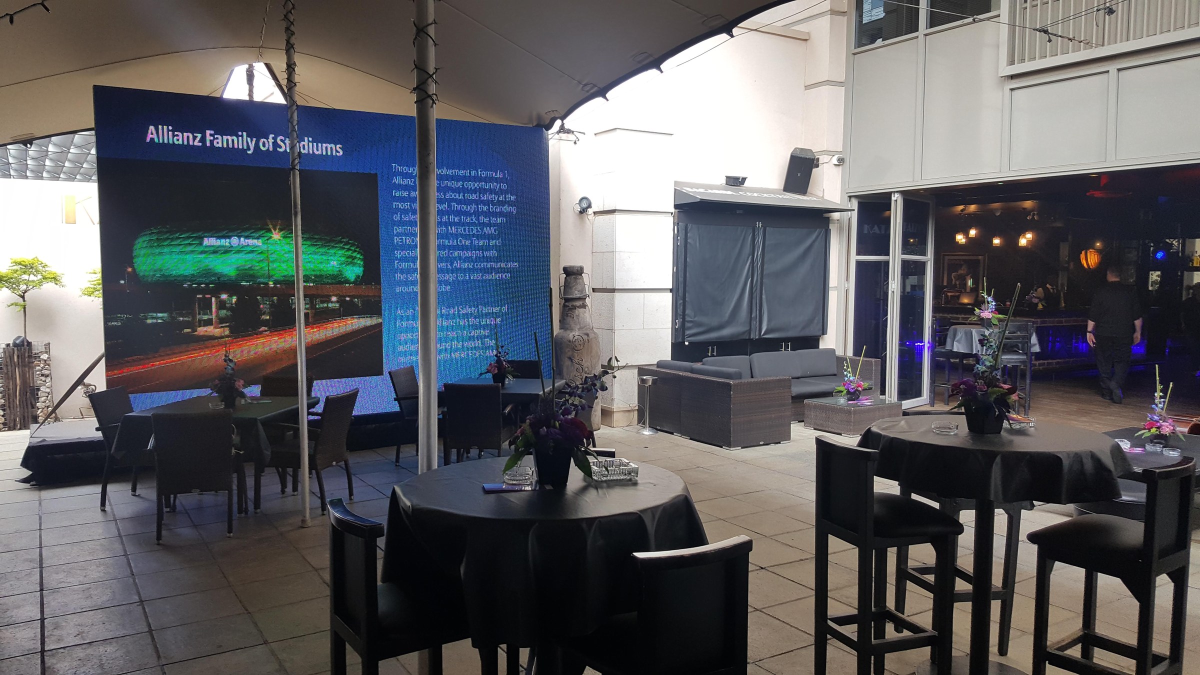 Patio with an Allianz Family of Stadiums LED wall and cocktail high-tops