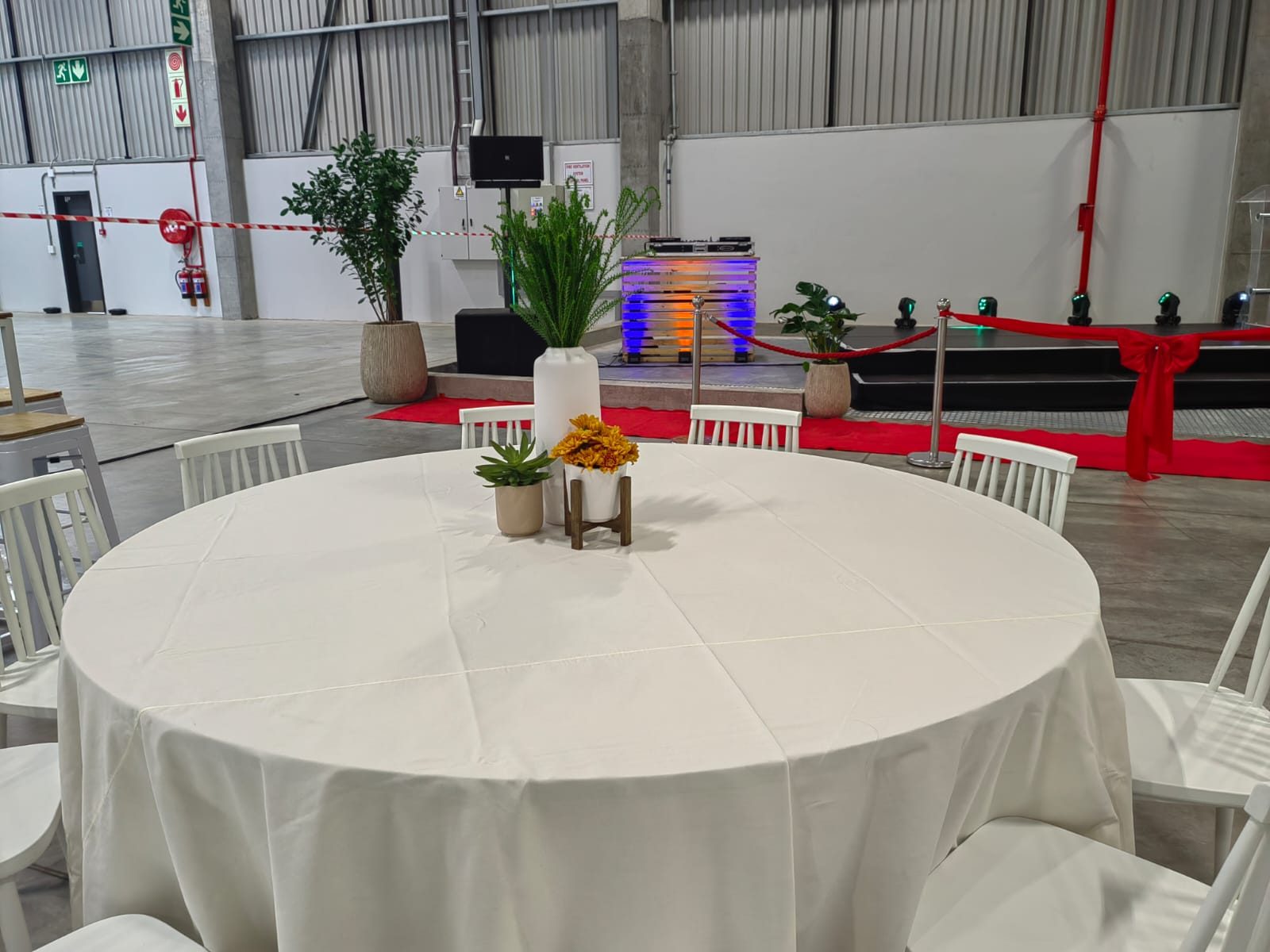 Round table in white linen with greenery centrepiece