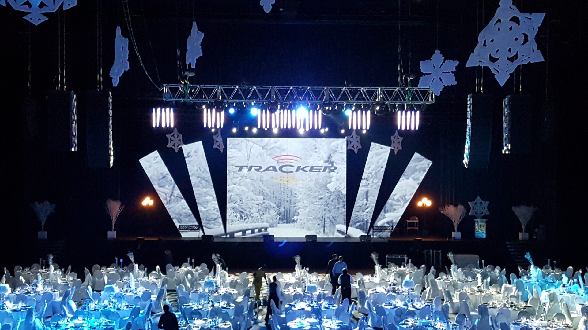 Stage with Tracker screens and hanging snowflakes