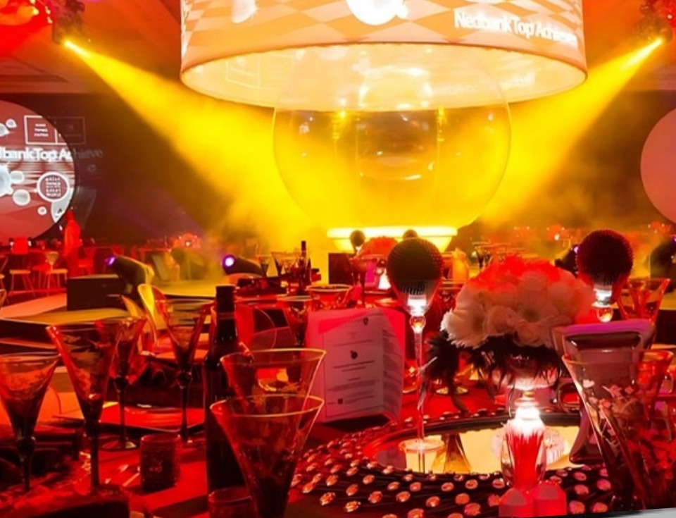 Red banquet table — glowing sphere and Nedbank Top Achievers overhead ring with circular screens
